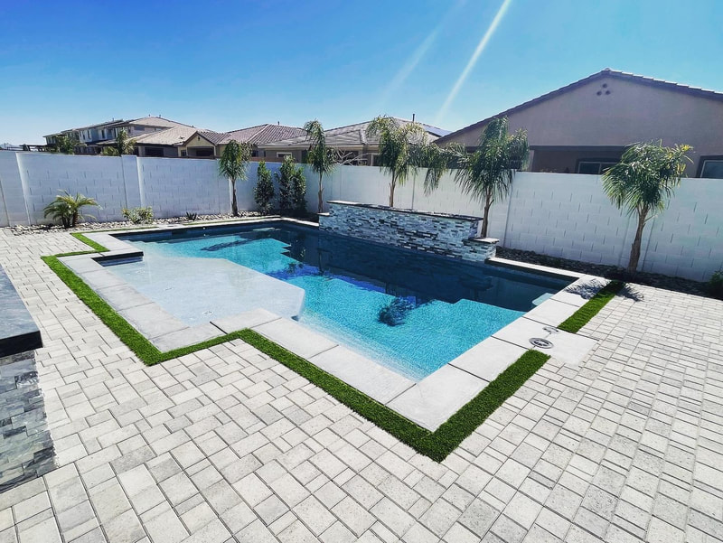 A luxurious travertine patio surrounding a pristine swimming pool.