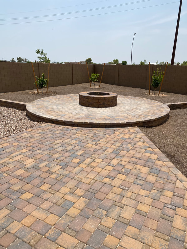  professionally installed hardscape featuring a flagstone patio with seating area, surrounded by lush greenery and accentuated by a stone fire pit. 
